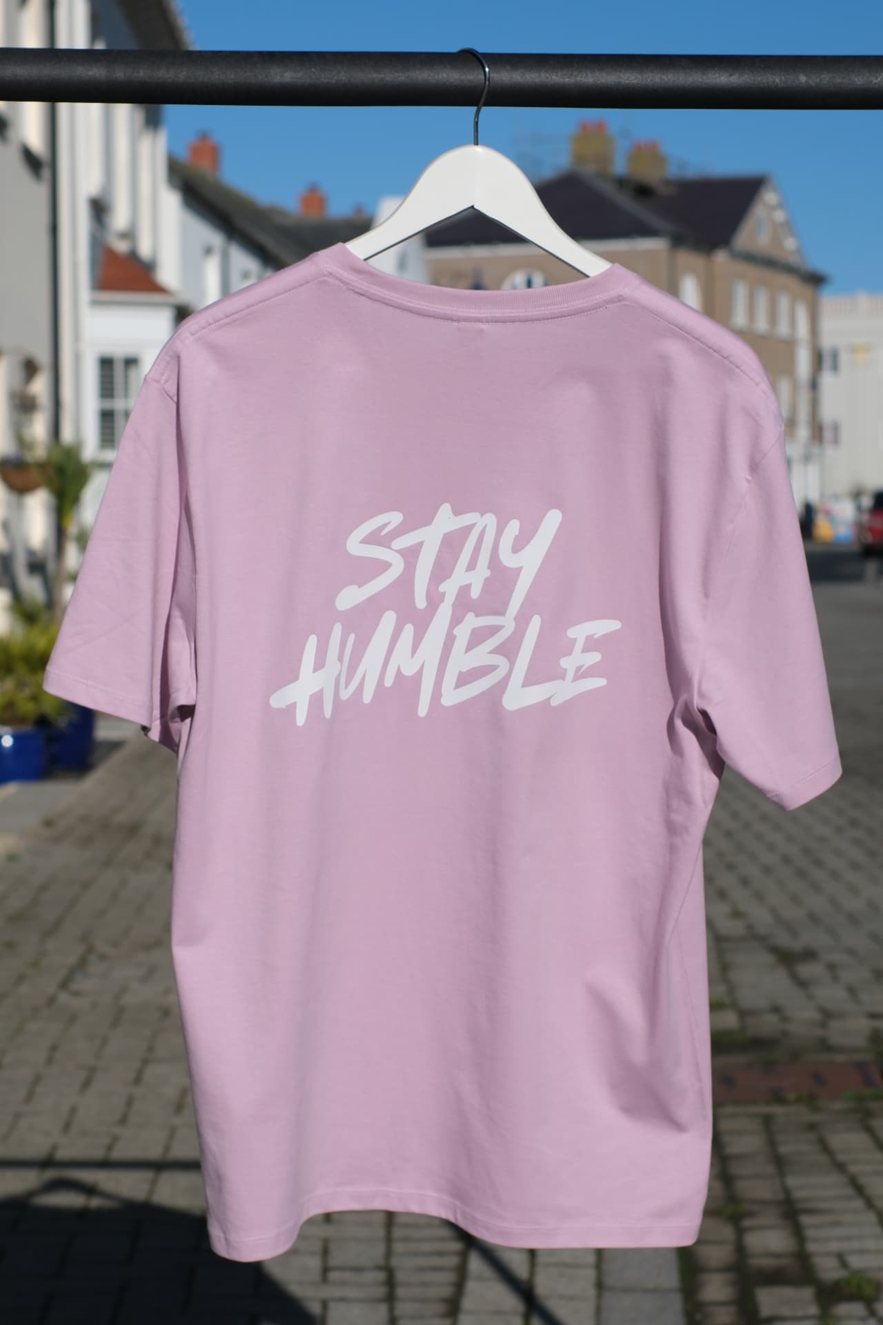 Back of the pink Stay Humble heavyweight T-shirt with the white hand-lettered back print